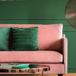 pink sofa with green cushions against green wall
