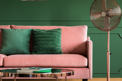 pink sofa with green cushions against green wall