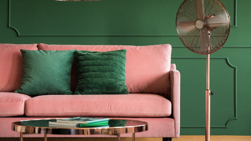 pink sofa with green cushions against green wall